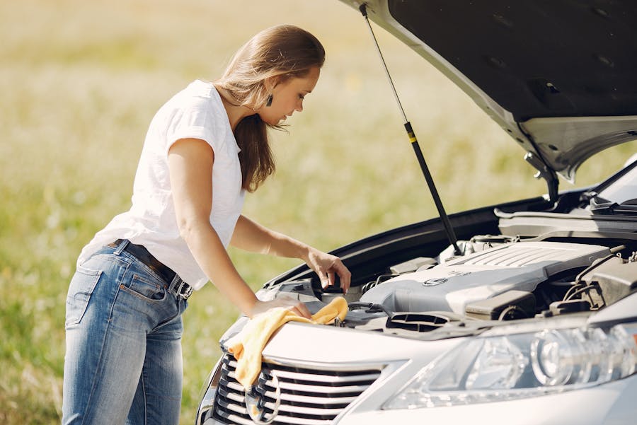 a woman looking at her car's engine bay